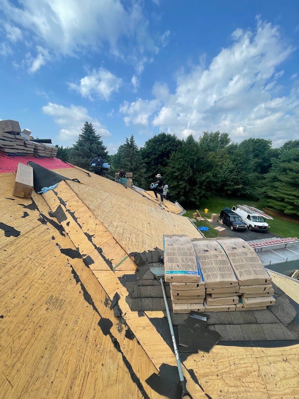 Essential Exteriors crew preparing exposed roof decking for new shingles
