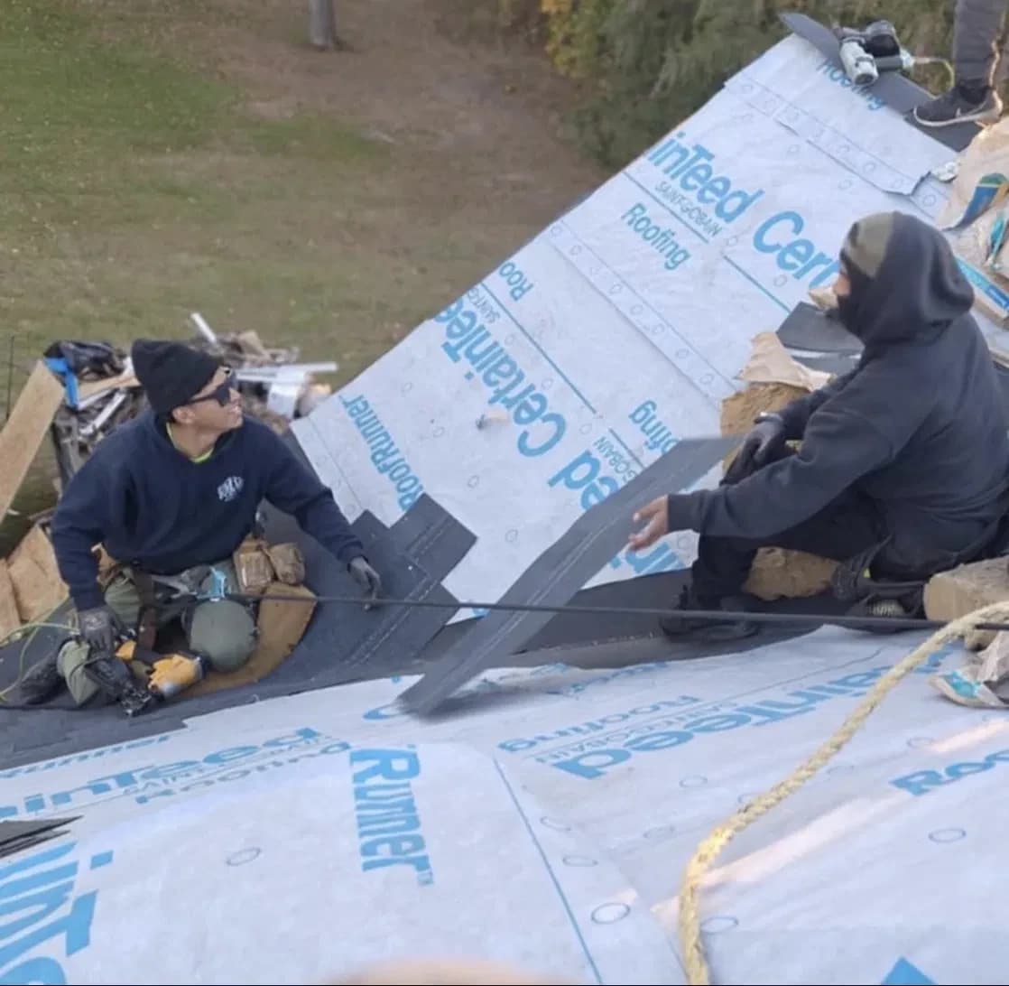 Jose and the Essential Exteriors crew laying CertainTeed underlayment on a West Michigan roof