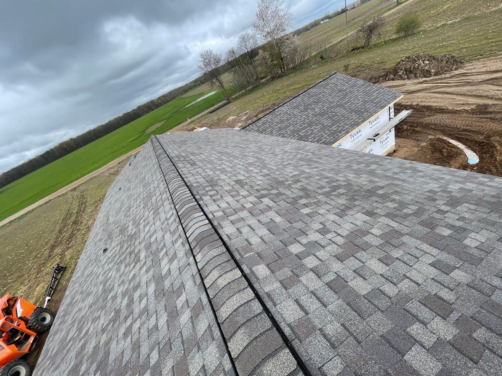 Finished gray architectural shingle roof on a West Michigan build, seen along the ridge