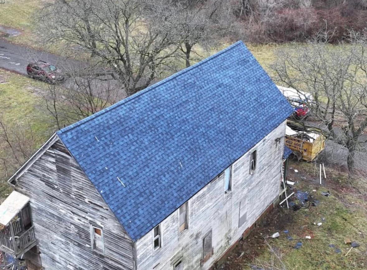 Same home after: finished architectural shingle roof, drone aerial