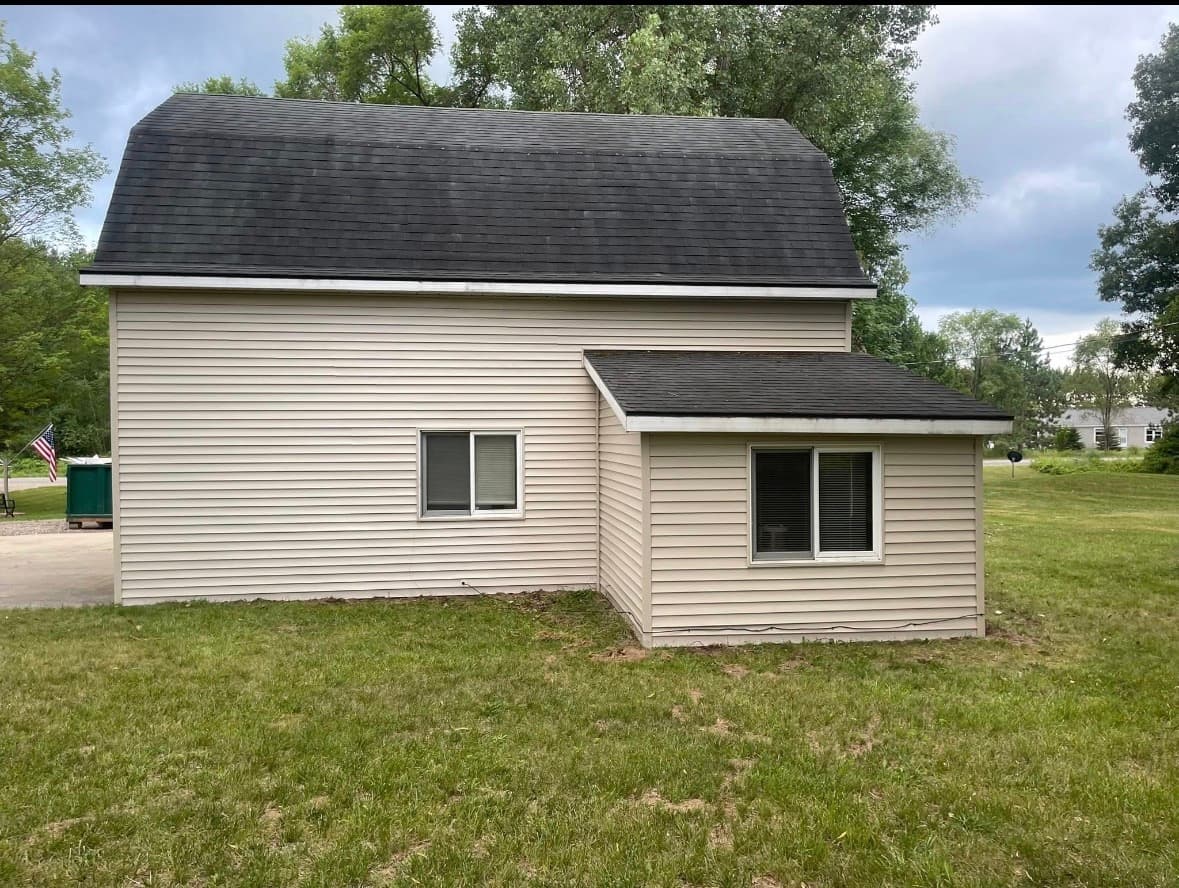 Fresh tan vinyl siding wrapping a West Michigan home and its addition