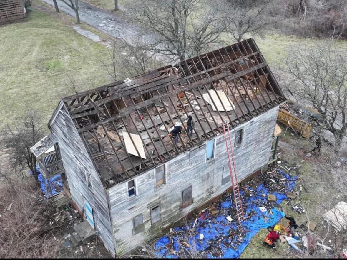 Home with the entire roof torn off to the rafters, drone aerial