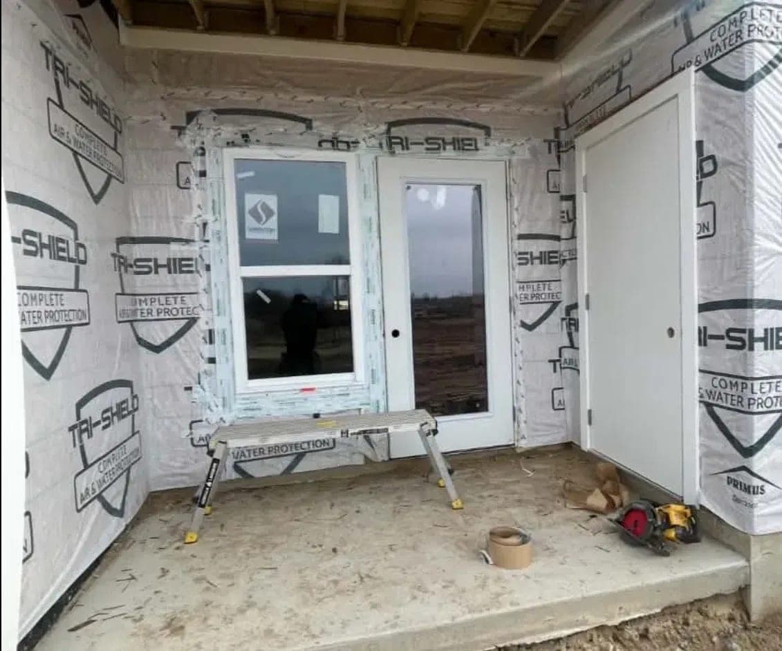 A large window and a glass patio door installed on a covered porch
